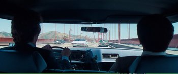 Movie still from “Magnum Force” (1973), directed by Ted Post – A view from inside a car looking out the window at the golden gate bridge in san francisco; Wide shot, Over the shoulder angle