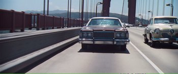 Movie still from “Magnum Force” (1973), directed by Ted Post – An old car driving on a bridge over a river; Extreme Wide shot, Low angle