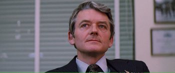 Movie still from “Magnum Force” (1973), directed by Ted Post – A person wearing a suit and tie; Close Up shot, Low angle