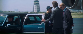Movie still from “Magnum Force” (1973), directed by Ted Post – A man and a woman standing in front of a car; Wide shot, Over the shoulder angle