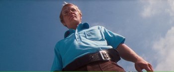 Movie still from “Magnum Force” (1973), directed by Ted Post – A man in a blue shirt and a brown belt; Medium shot, Low angle