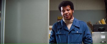 Movie still from “Magnum Force” (1973), directed by Ted Post – A man in a blue jacket standing in front of a white wall; Close Up shot, Low angle