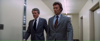 Movie still from “Magnum Force” (1973), directed by Ted Post – Two men in suits and ties walking in a hallway; Medium shot, Low angle