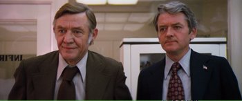 Movie still from “Magnum Force” (1973), directed by Ted Post – Two men in business suits standing next to each other; Close Up shot, Low angle