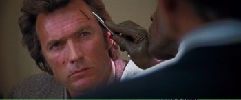 Movie still from “Magnum Force” (1973), directed by Ted Post – A man is getting his head waxed by another man; Close Up shot, Over the shoulder angle