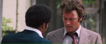 Movie still from “Magnum Force” (1973), directed by Ted Post – A man in a suit and tie talking to another man in a suit and tie; Close Up shot, Over the shoulder angle