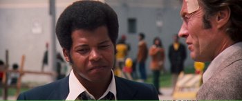 Movie still from “Magnum Force” (1973), directed by Ted Post – A person wearing a suit and tie; Close Up shot, Over the shoulder angle