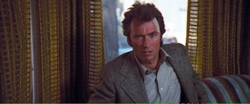 Movie still from “Magnum Force” (1973), directed by Ted Post – A person wearing a suit and tie; Close Up shot, Over the shoulder angle