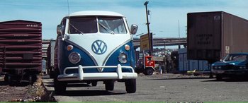 Movie still from “Magnum Force” (1973), directed by Ted Post – A blue and white van is parked on the side of the road; Wide shot, Low angle