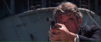 Movie still from “Magnum Force” (1973), directed by Ted Post – A man holding a gun with blood all over his face; Close Up shot, Low angle