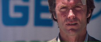 Movie still from “Magnum Force” (1973), directed by Ted Post – A person with a red spot on his face; Close Up shot, Low angle