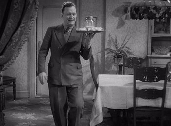 Movie still from “Make Way for Tomorrow” (1937), directed by Leo McCarey – A black and white photo of a man in a suit holding a tray; Medium shot, High angle