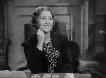 Movie still from “Make Way for Tomorrow” (1937), directed by Leo McCarey – An older woman sitting at a table with cards in front of a fireplace; Medium shot, High angle
