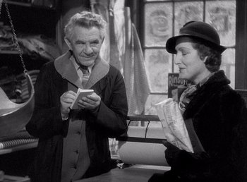 Movie still from “Make Way for Tomorrow” (1937), directed by Leo McCarey – An older man and a woman looking at a cell phone; Medium shot, High angle