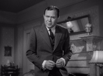 Movie still from “Make Way for Tomorrow” (1937), directed by Leo McCarey – A man in a suit and tie standing in front of a fireplace; Medium shot, Over the shoulder angle