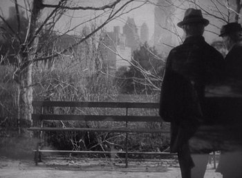 Movie still from “Make Way for Tomorrow” (1937), directed by Leo McCarey – A man standing in front of a fence with a city in the background; Wide shot, High angle