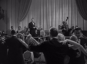 Movie still from “Make Way for Tomorrow” (1937), directed by Leo McCarey – A black and white photo of a man in front of an orchestra; Wide shot, Over the shoulder angle