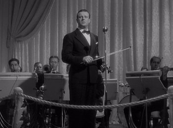 Movie still from “Make Way for Tomorrow” (1937), directed by Leo McCarey – A man in a suit and bow tie holding a pipe; Medium shot, Low angle