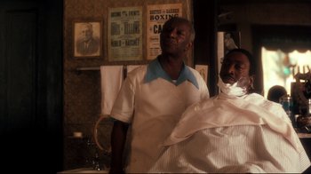 Movie still from “Malcolm X” (1992), directed by Spike Lee – Two men standing next to each other in front of a mirror; Medium shot, Over the shoulder angle