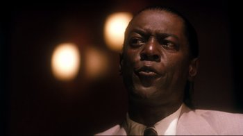 Movie still from “Malcolm X” (1992), directed by Spike Lee – A person wearing a suit and tie; Close Up shot, Low angle