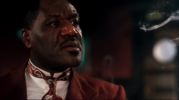 Movie still from “Malcolm X” (1992), directed by Spike Lee – A person wearing a suit and tie; Close Up shot, Low angle