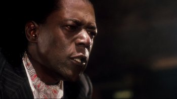 Movie still from “Malcolm X” (1992), directed by Spike Lee – A man's face in a dark room; Close Up shot, Low angle