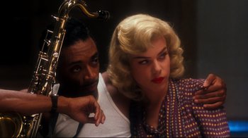 Movie still from “Malcolm X” (1992), directed by Spike Lee – A man and a woman sitting next to each other; Close Up shot, Over the shoulder angle