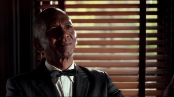 Movie still from “Malcolm X” (1992), directed by Spike Lee – A person wearing a suit and bow tie; Close Up shot, Over the shoulder angle