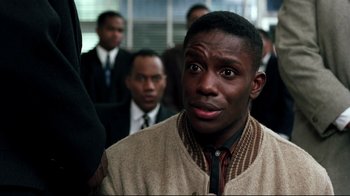 Movie still from “Malcolm X” (1992), directed by Spike Lee – A person with a crowd of people in the background; Close Up shot, Over the shoulder angle