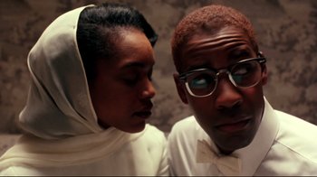 Movie still from “Malcolm X” (1992), directed by Spike Lee – A man and a woman wearing glasses and a white dress; Close Up shot, Over the shoulder angle