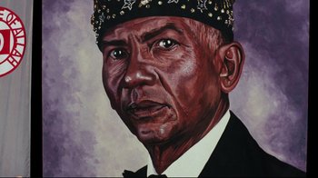 Movie still from “Malcolm X” (1992), directed by Spike Lee – A painting of an older man wearing a crown; Extreme Close Up shot, Low angle