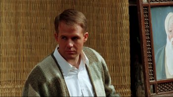 Movie still from “Malcolm X” (1992), directed by Spike Lee – A man wearing a white shirt and a brown cardigan; Medium shot, Over the shoulder angle