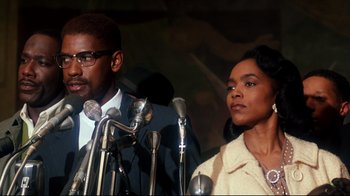 Movie still from “Malcolm X” (1992), directed by Spike Lee – A man and a woman standing in front of microphones; Close Up shot, Low angle