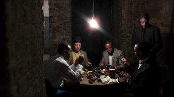 Movie still from “Malcolm X” (1992), directed by Spike Lee – A group of men sitting at a table in a room; Wide shot, High angle