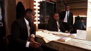 Movie still from “Malcolm X” (1992), directed by Spike Lee – A group of men sitting at a table in front of a mirror; Medium shot, Over the shoulder angle