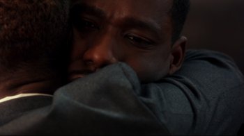 Movie still from “Malcolm X” (1992), directed by Spike Lee – A person with their eyes closed; Extreme Close Up shot, Over the shoulder angle