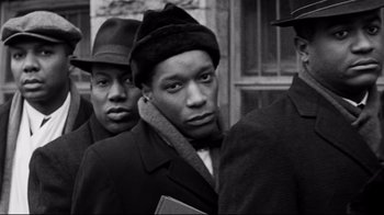 Movie still from “Malcolm X” (1992), directed by Spike Lee – A black and white photo of a man in a hat; Close Up shot, High angle