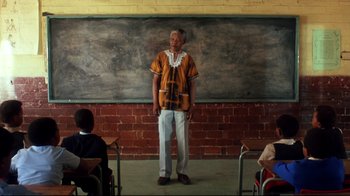 Movie still from “Malcolm X” (1992), directed by Spike Lee – An old man standing in front of an old brick wall; Wide shot, Low angle