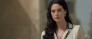 Movie still from “Malena” (2000), directed by Giuseppe Tornatore – A woman with long black curly hair wearing a white shirt; Close Up shot, Over the shoulder angle