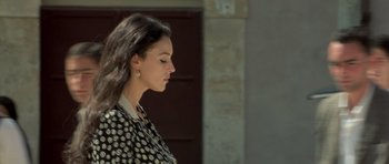 Movie still from “Malena” (2000), directed by Giuseppe Tornatore – A woman in a polka dot jacket looking down; Close Up shot, Over the shoulder angle