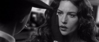 Movie still from “Malena” (2000), directed by Giuseppe Tornatore – A black - and - white photo of a woman getting her hair done; Close Up shot, Over the shoulder angle