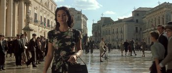 Movie still from “Malena” (2000), directed by Giuseppe Tornatore – A woman walking down the street with a purse; Medium shot, Over the shoulder angle