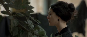 Movie still from “Malena” (2000), directed by Giuseppe Tornatore – A beautiful woman with her eyes closed next to a plant; Close Up shot, Over the shoulder angle