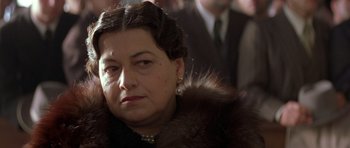 Movie still from “Malena” (2000), directed by Giuseppe Tornatore – An older woman wearing a fur coat and pearl earrings; Close Up shot, Over the shoulder angle
