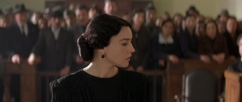 Movie still from “Malena” (2000), directed by Giuseppe Tornatore – A woman in a black dress is looking to the side; Close Up shot, Over the shoulder angle