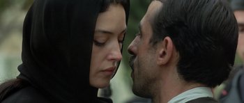 Movie still from “Malena” (2000), directed by Giuseppe Tornatore – A man and a woman face to face in front of a building; Close Up shot, Over the shoulder angle