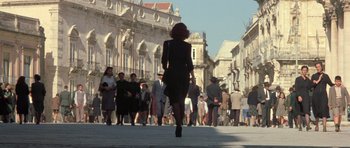 Movie still from “Malena” (2000), directed by Giuseppe Tornatore – A crowd of people walking down a street; Extreme Wide shot, Low angle