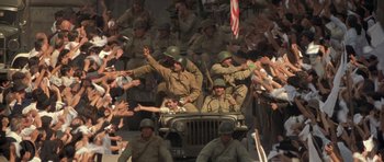 Movie still from “Malena” (2000), directed by Giuseppe Tornatore – A group of men dressed in military fatigues riding in an army jeep; Wide shot, High angle
