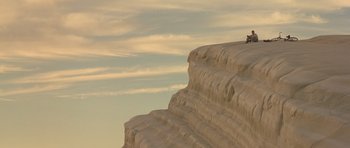 Movie still from “Malena” (2000), directed by Giuseppe Tornatore – A cat sitting on top of a rock formation; Extreme Wide shot, Low angle