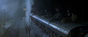Movie still from “Malena” (2000), directed by Giuseppe Tornatore – A group of people sitting on top of a train; Extreme Wide shot, High angle